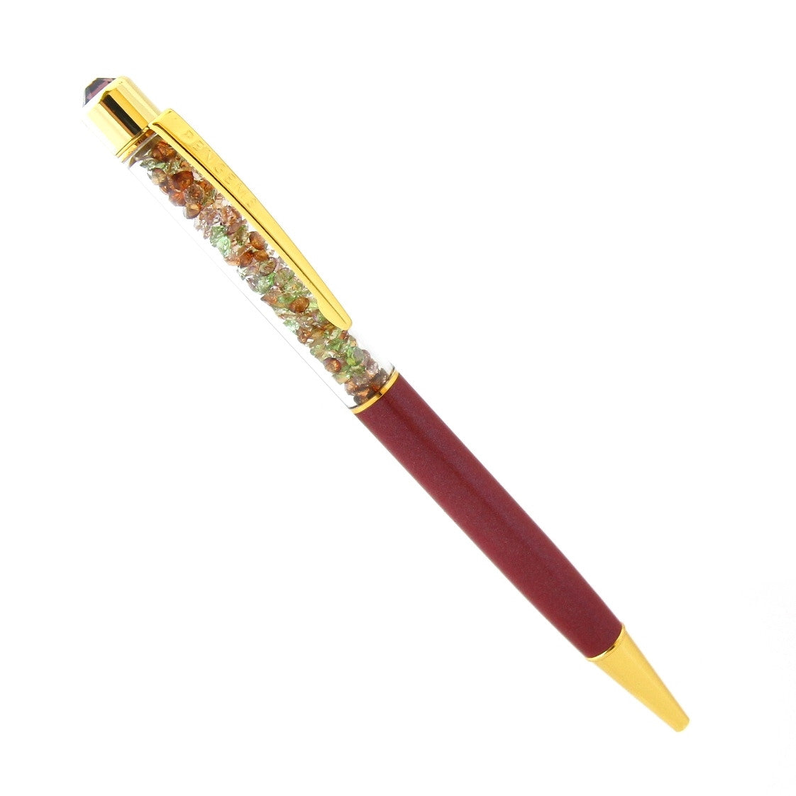 A burgundy crystal pen with gold hardware and a chamber of green and amber crystal chatons.