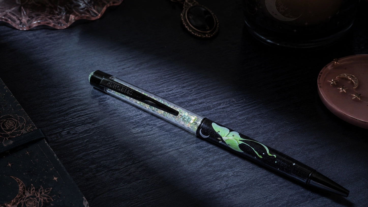 Decorative pen on a dark surface with a candle in the background