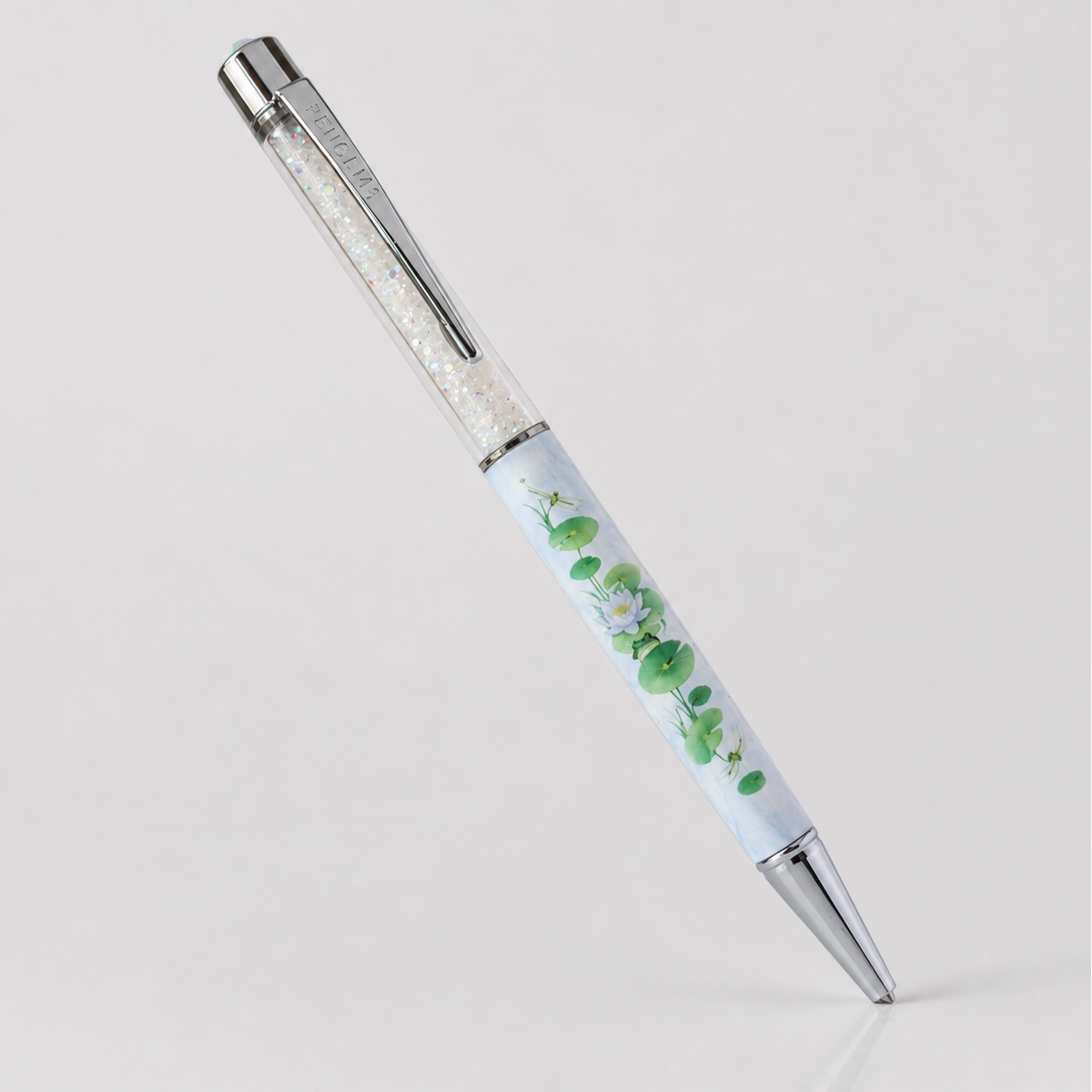 Lilypad Lounge crystal pen on a plain gray background, showing the full lily pad and water lily print with chrome hardware and aurora crystal fill.